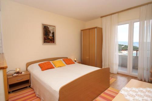 a bedroom with a bed and a large window at Apartments and rooms with parking space Jelsa, Hvar - 8798 in Jelsa