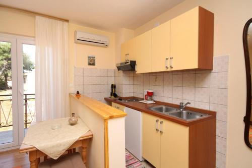 a small kitchen with a sink and a table at Apartments and rooms with parking space Jelsa, Hvar - 8798 in Jelsa