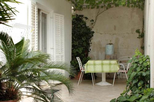 une table et des chaises sur une terrasse agrémentée de plantes dans l'établissement Apartments with a parking space Mlini, Dubrovnik - 8834, à Mlini
