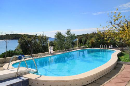 een groot zwembad met blauw water bij Seaside apartments with a swimming pool Zecevo Rtic, Rogoznica - 8366 in Rogoznica