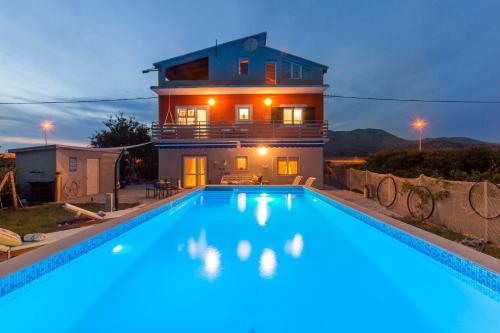a villa with a swimming pool in front of a house at Holiday house with a swimming pool Opuzen, Neretva Delta - Usce Neretve - 8818 in Opuzen