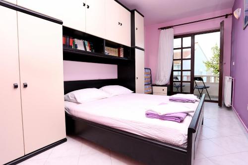 sypialnia z dużym łóżkiem i fioletowymi ścianami w obiekcie Apartment Zecevo Rtic 10334a w Rogoznicy