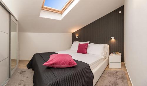 a bedroom with a large white bed with red pillows at Apartments and rooms with parking space Rogoznica - 10339 in Rogoznica