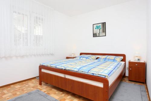 a bedroom with a bed and a window at Apartments with a parking space Omis - 10349 in Omiš