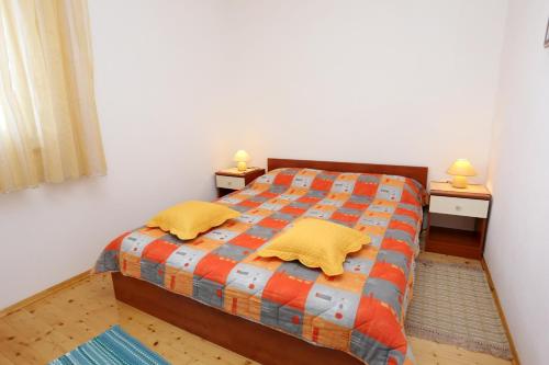 1 dormitorio con 1 cama con 2 almohadas amarillas en Apartments by the sea Drvenik Veliki, Drvenik - 10346, en Veliki Drvenik
