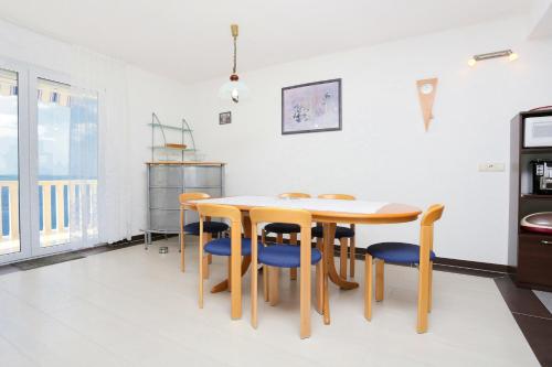 a dining room with a table and blue chairs at Apartments with a parking space Omis - 10349 in Omiš