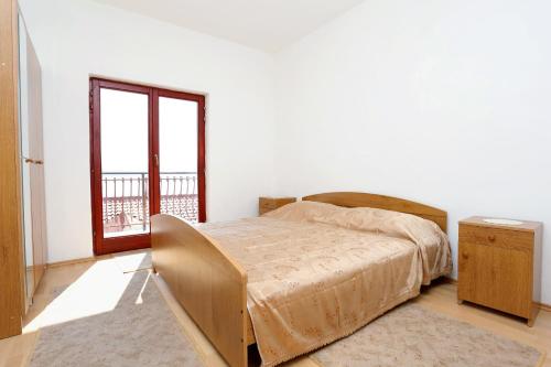 1 dormitorio con cama y ventana grande en Apartments with a parking space Lokva Rogoznica, Omis - 10358 en Lokva Rogoznica