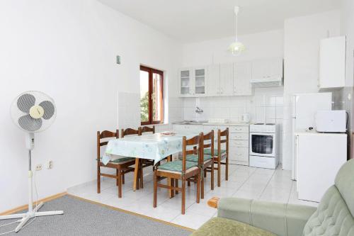 cocina con mesa, sillas y nevera en Apartments with a parking space Lokva Rogoznica, Omis - 10358 en Lokva Rogoznica