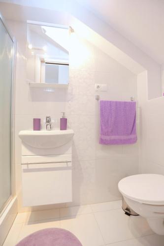 a white bathroom with a sink and a toilet at Apartments with parking space Omis - 10362 in Omiš