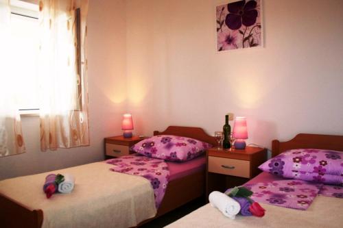 1 dormitorio con 2 camas y 2 velas rosas en Holiday house with a swimming pool Bol, Brac - 11016, en Bol