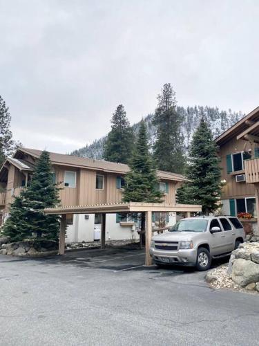 a suv parked in front of a building with trees at Walk to Downtown Leavenworth * Sleeps 6 + Pets * Ground Level Gem! in Leavenworth