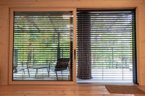 two large windows with blinds on them in a room at Nomád Glamping in Noszvaj