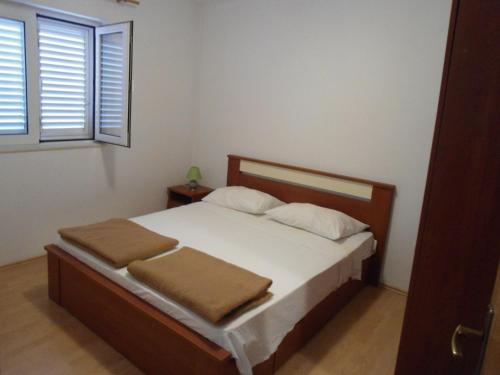 Schlafzimmer mit einem Bett mit weißer Bettwäsche und einem Fenster in der Unterkunft Apartments by the sea Sobra, Mljet - 11011 in Sobra