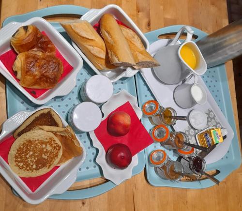 a table topped with trays of bread and toast at Ô ptit gîte d'Ogenne in Ogenne-Camptort