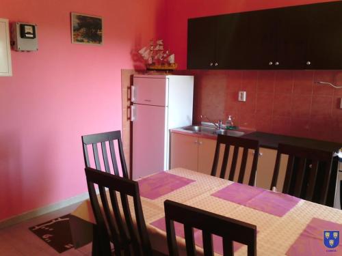 uma cozinha com uma mesa e um frigorífico branco em Apartments with a parking space Kastel Stafilic, Kastela - 11022 em Kaštela