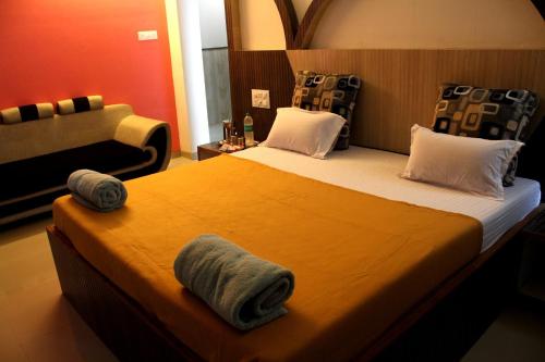 シルディにあるMalhar palace hotelのベッドルーム1室(大型ベッド1台、タオル付)