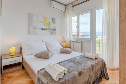 a bedroom with a large bed with two pillows on it at Apartments by the sea Slatine, Ciovo - 11047 in Slatine