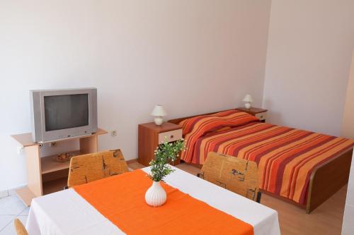 ein kleines Schlafzimmer mit 2 Betten und einem TV in der Unterkunft Studio Bibinje 11074b in Bibinje