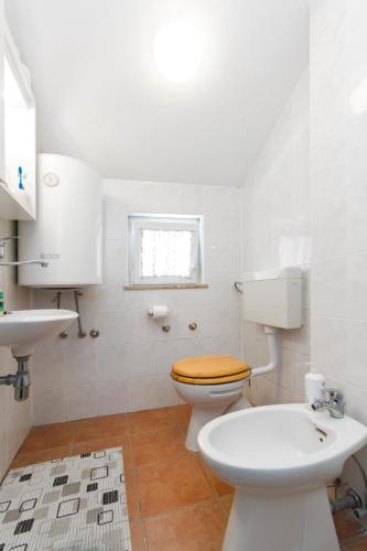 a white bathroom with a toilet and a sink at Holiday house with a parking space Kasic, Sibenik - 11079 in Pirovac