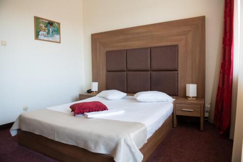 a bedroom with a large bed with a large headboard at Hotel Panoramic in Râmnicu Vâlcea