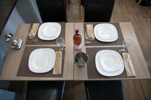 a table with white plates and wine glasses on it at Hotel Panoramic in Râmnicu Vâlcea