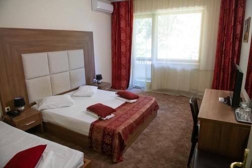 a hotel room with a bed and a window at Hotel Panoramic in Râmnicu Vâlcea