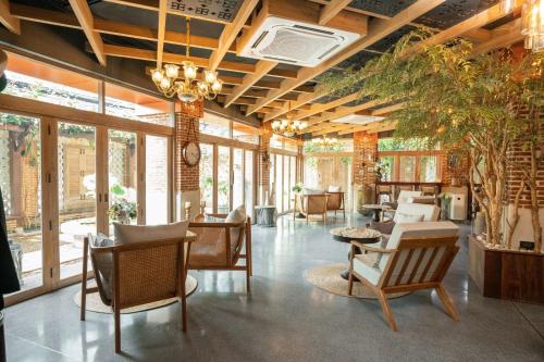 a lobby with chairs and tables and windows at Sanae' Oldtown Hotel in Chiang Mai