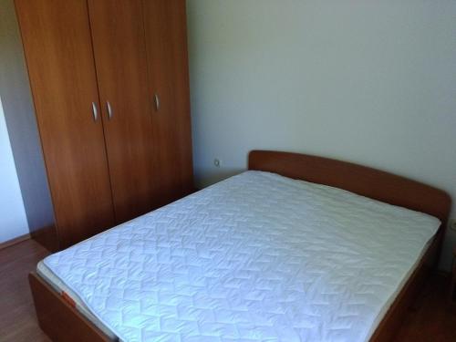 a small bedroom with a bed and a wooden cabinet at Apartments by the sea Hodilje, Peljesac - 11189 in Ston