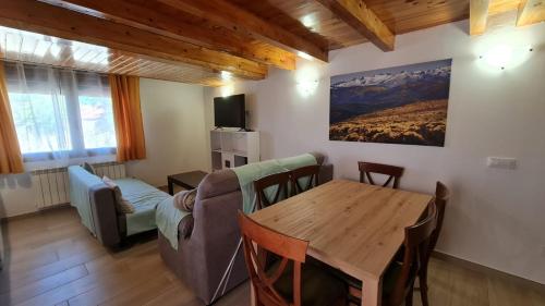 uma sala de estar com uma mesa e um sofá em Casa rural los 7 pinos de Gredos em Navarredonda de Gredos