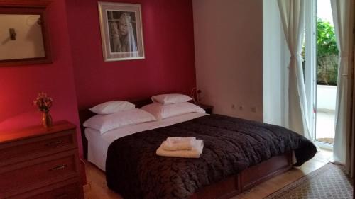 - une chambre rouge avec un lit et des oreillers blancs dans l'établissement Apartments and rooms with parking space Dubrovnik - 11207, à Dubrovnik