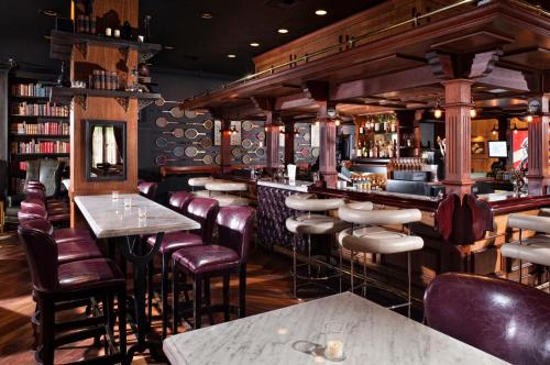 un bar avec des chaises et des tables en cuir dans un restaurant dans l'établissement Los Angeles Athletic Club, à Los Angeles