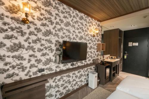 チェンマイにあるSanae' Oldtown Hotelの花の壁紙で覆われたベッドルーム1室