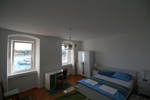 a bedroom with a bed and a window at Apartments by the sea Krk - 11205 in Krk