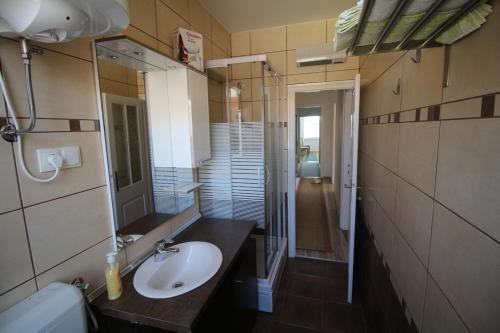 ein Bad mit einem Waschbecken und einem Spiegel in der Unterkunft Apartments by the sea Krk - 11205 in Krk
