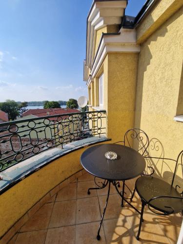 a table and chairs on a balcony with a view at Danube duplex apartment in Smederevo