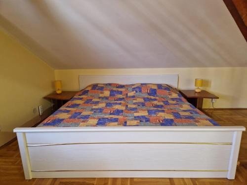 a bed with a quilt on it in a bedroom at Danube duplex apartment in Smederevo