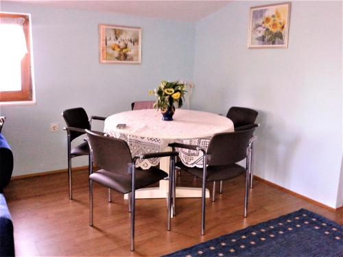 uma mesa de jantar com cadeiras e um vaso de flores em Apartments with a parking space Barbariga, Fazana - 11193 em Barbariga