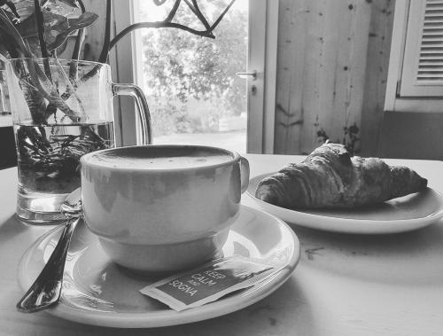 a cup of coffee and a plate of food on a table at Ca' San Michele in Asti