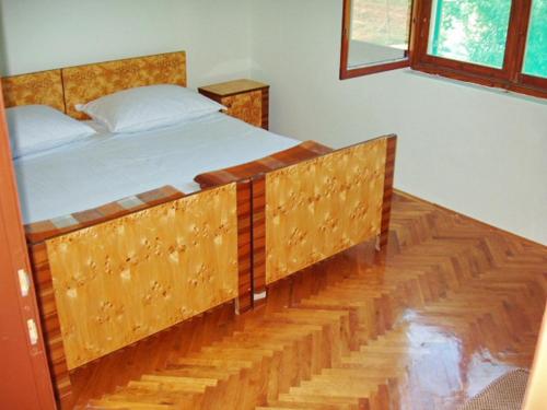 Cama grande en habitación con suelo de madera en Apartments with a parking space Betina, Murter - 11322 en Betina