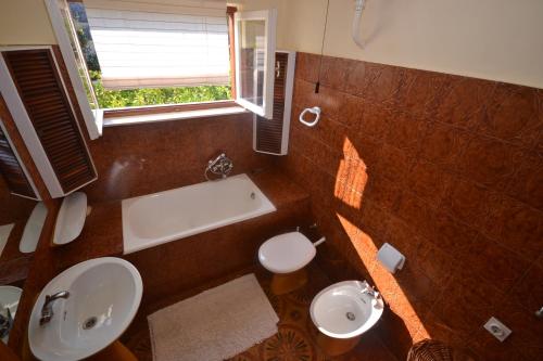 a bathroom with a tub and a sink and a toilet at Apartments by the sea Splitska, Brac - 11339 in Splitska