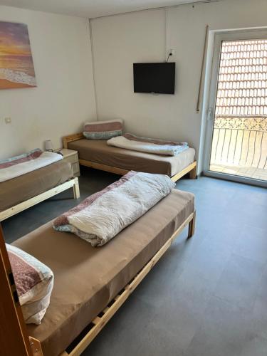 a room with three beds and a flat screen tv at Gartenappartment in Alzenau
