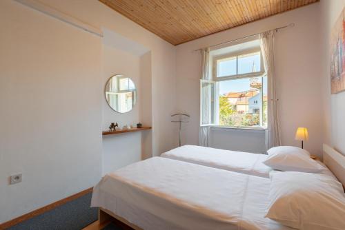 a bedroom with two beds and a window at Apartment Jelsa 11319a in Jelsa
