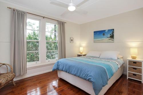 a bedroom with a bed and two windows at Beach Shack in Hawks Nest