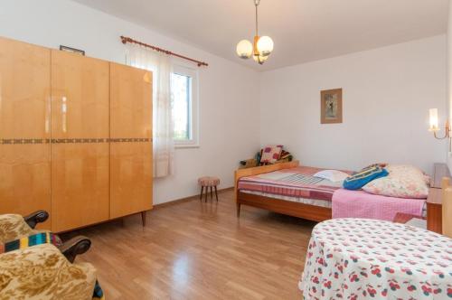 a bedroom with two beds and a dresser at Apartments with a parking space Mali Losinj (Losinj) - 11344 in Mali Lošinj