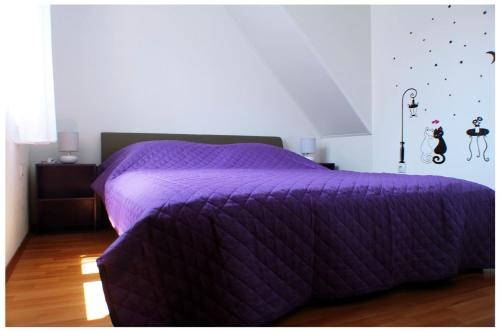 a bed with a purple comforter in a bedroom at Apartments by the sea Razanj, Rogoznica - 11347 in Rogoznica