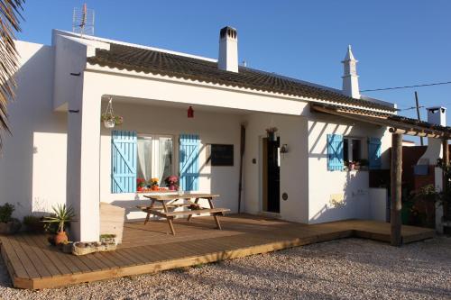 a small white house with a wooden deck at PuraVida Divehouse in Sagres