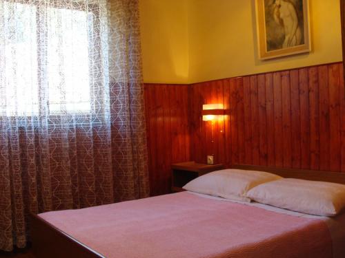 Dormitorio pequeño con cama y ventana en Apartments by the sea Jadrija, Sibenik - 11356 en Šibenik