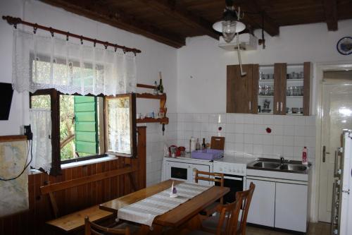 a kitchen with a wooden table and a sink and a window at Secluded fisherman's cottage Cove Nevidjansko Polje, Pasman - 11392 in Neviđane