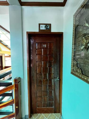 a wooden door in a room with a picture on the wall at Balay Paragua in El Nido