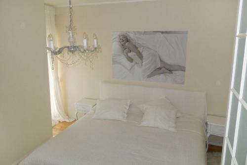 a bedroom with a white bed with a picture on the wall at Apartments with a swimming pool Zagreb - 11408 in Zagreb
